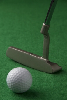 golf club and golf ball on a green background