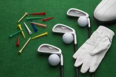 different golf accessories on green background