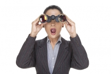 business girl shocked to see something through binocular 