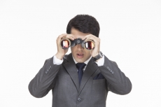businessman in surprise after looking something from binoculars 