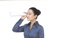 girl looking through rolled sheet of paper