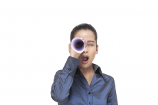 girl looking through rolled sheet of paper in surprise