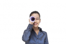 girl looking at the front through rolled sheet of paper 