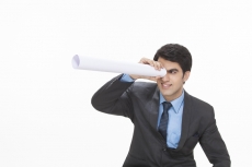 man looking through rolled chart hole 