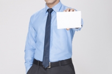 man holding white placard with one hand and other hand in pocket 