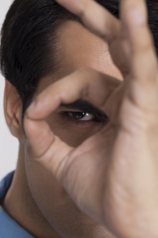man looking at the camera through hand hole