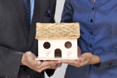 close up of couple hands holding home miniature  