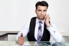man at his office desk and talking on phone 