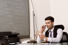 man at his office desk and talking on phone 