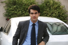man leaning against his car