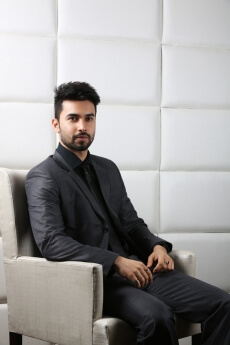 man in formals sitting with poise