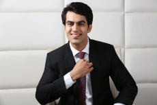 man sitting and fixing his tie