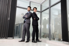 men in formals standing back to back