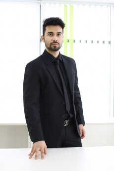 man in formal wear standing in his office cabin 