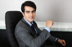 man in formals sitting on his chair 