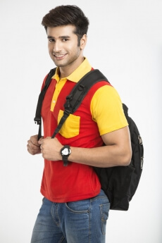 guy posing while holding bag straps 