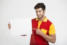 man smiling while pointing at placard