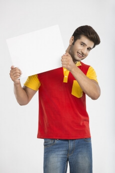 man showing white board while smiling for the camera 
