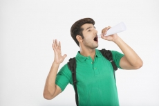 college boy using rolled sheet as loudspeaker