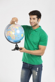 man showing globe while smiling 