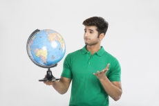 man gesturing while looking at the world globe map