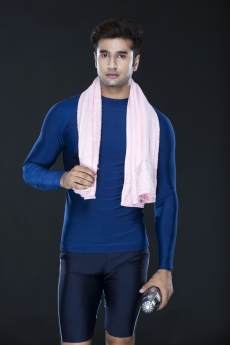 man after workout holding a sipper while looking at the camera 