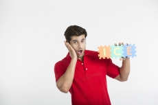 guy posing in surprise while holding a jigsaw puzzle
