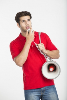 young man posing while speaking on loudspeaker 
