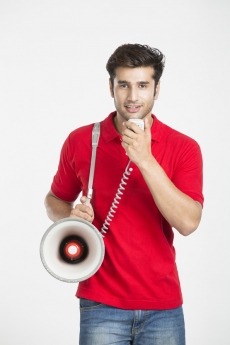 guy talking on loudspeaker while posing 