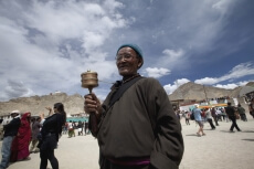 buddhist monk holding a praying wheel