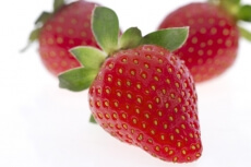 close up shot of three strawberries lying 