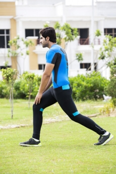 side pose of a man stretching in park 