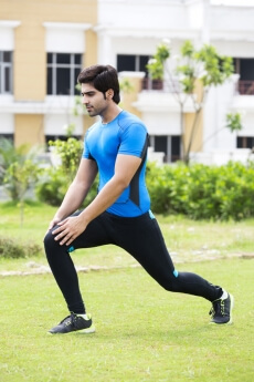 young man stretching in park  