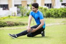 young boy exercising in park 