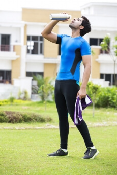 man drinking water from bottle after workout 