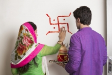 couple making swasthik in their new home 