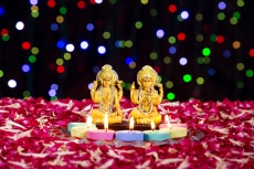 lord ganesha and luxmi statues with diyas in front