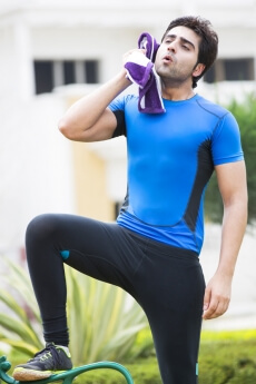 man wiping off his sweat after workout