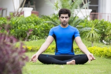 boy doing meditation in park 