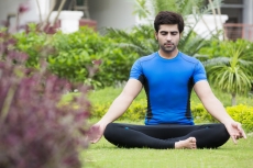boy doing meditation in park 