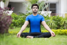 boy practicing yoga in park 