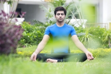 boy practicing yoga early morning in park 