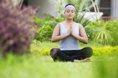 girl practicing yoga in park with eyes closed 