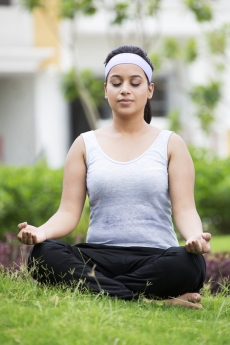 girl doing padamsana in park with eyes closed 