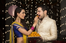 wife feeding ladoo to husband 