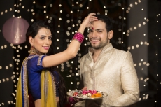 couple celebrating diwali and wife applying tika to husband 