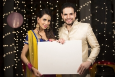 couple in traditional wear holding a message board