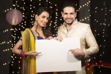 couple pointing towards a message board on diwali