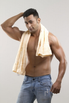 man with muscular built posing with a towel