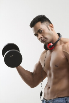 man posing with dumbbells and headphones